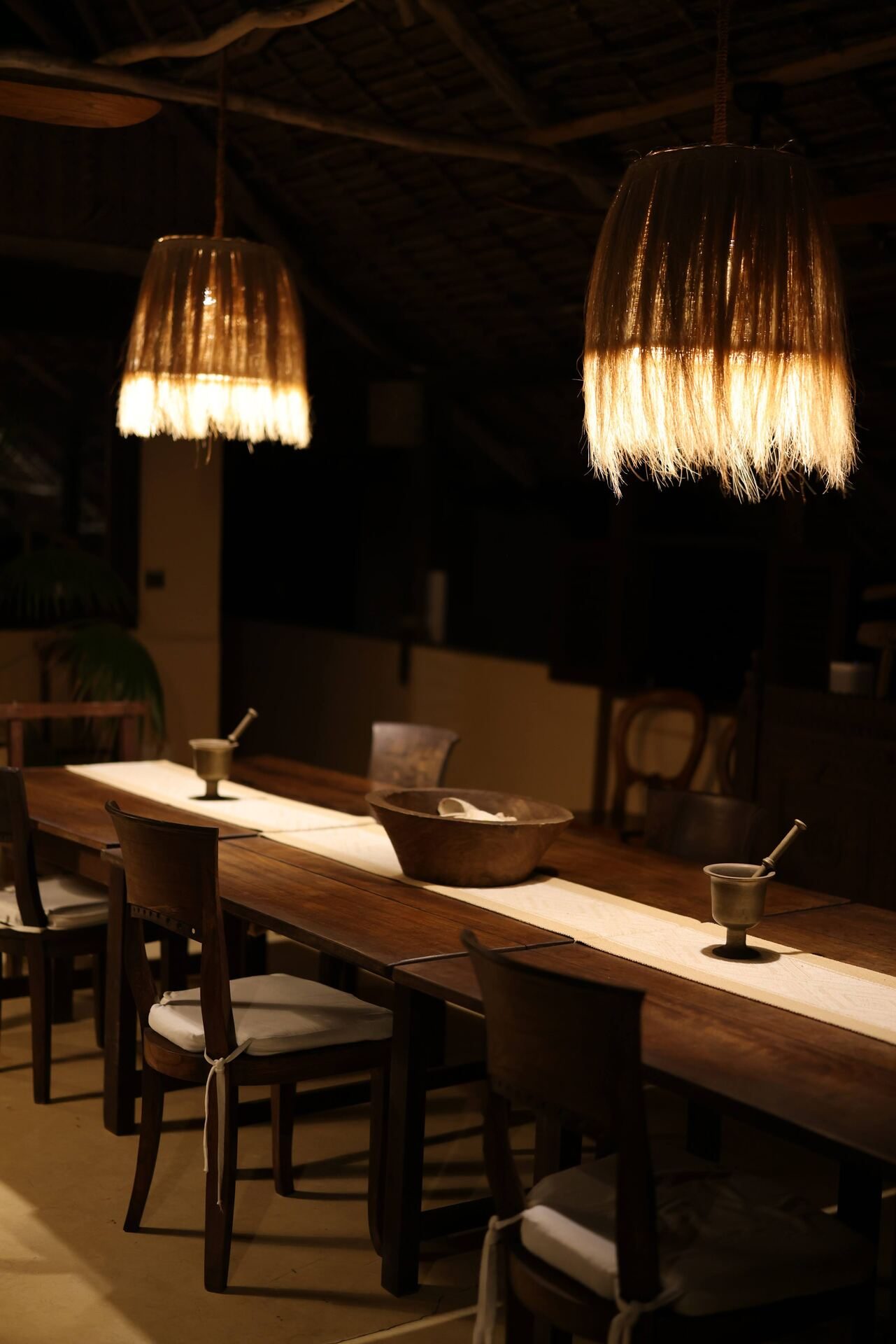The long wooden dining table set for dinner