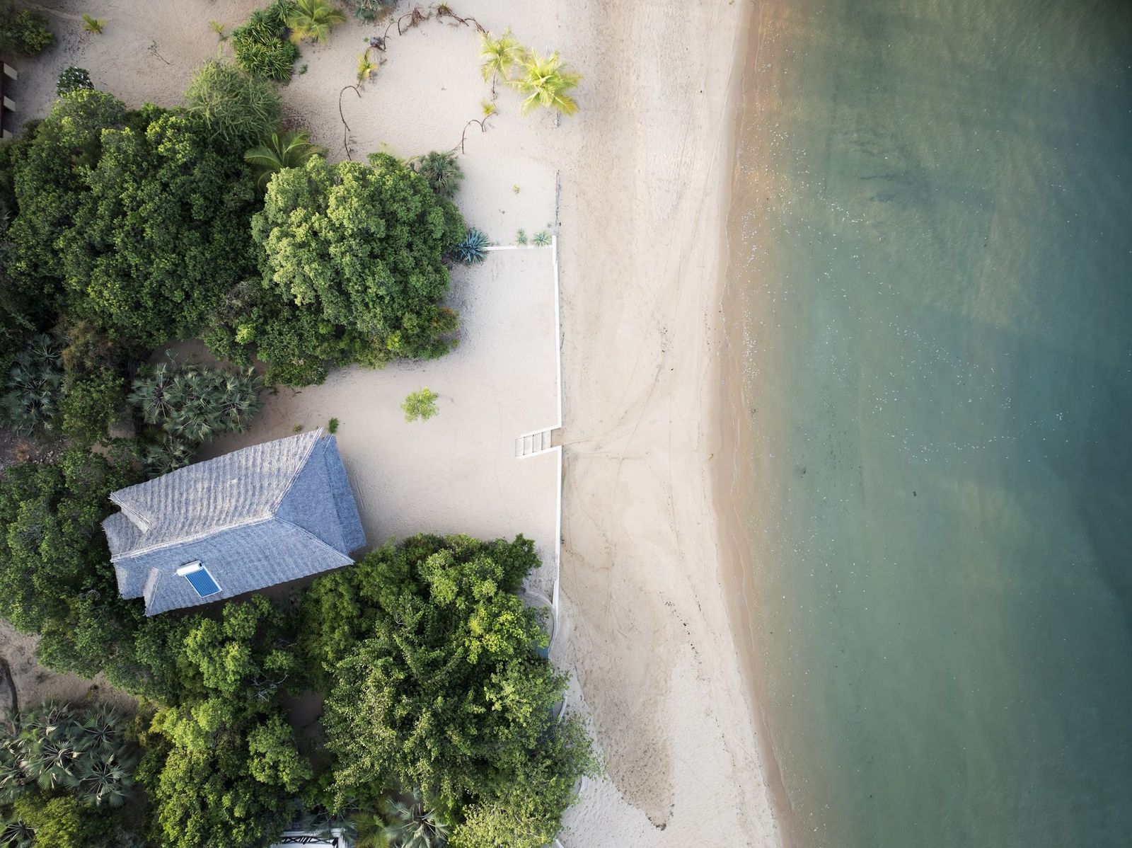 Makai cabana — carved Lamu door open to a private outdoor courtyard with a daybed