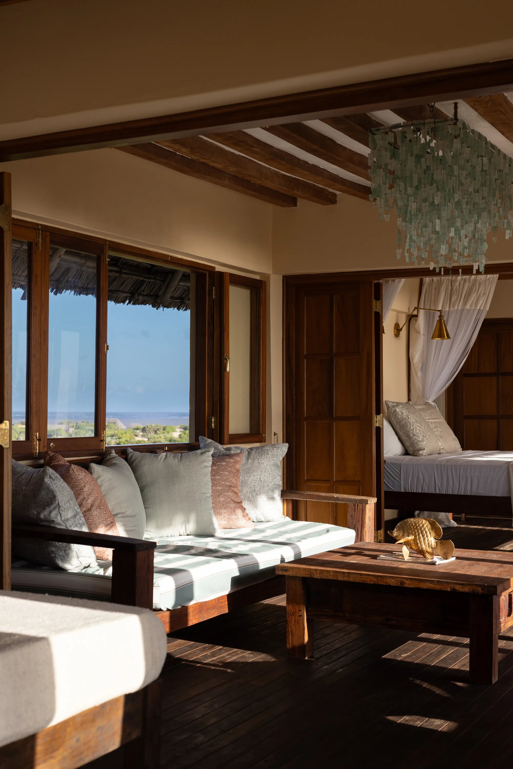 Kailani cabana, daybed under the sea-glass chandelier with the ocean beyond