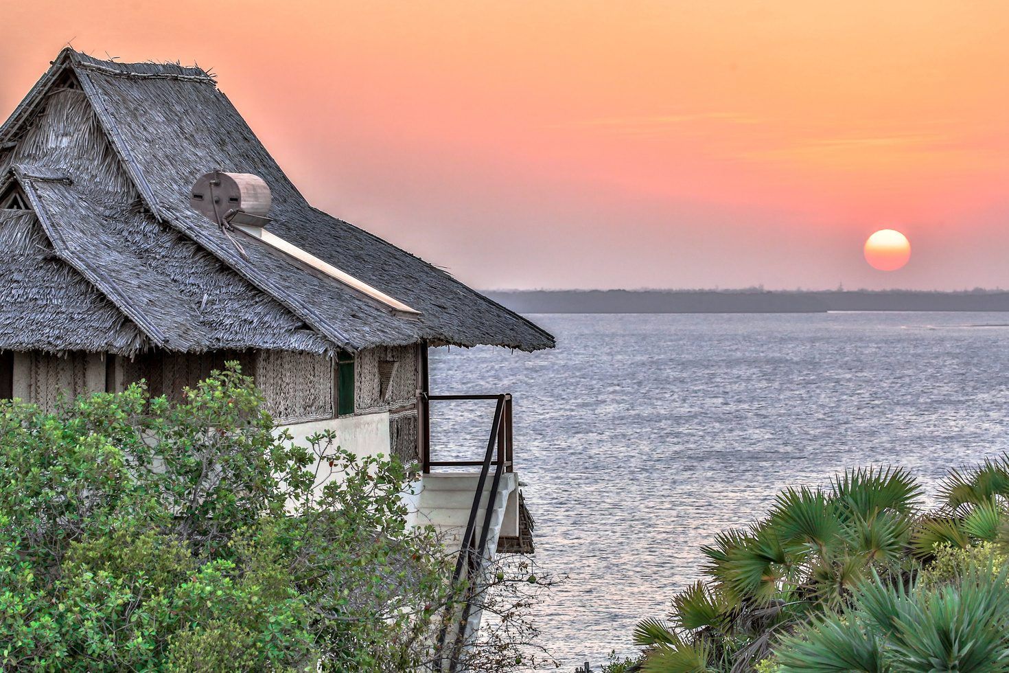 Lōkahi cabana — gauzy curtains framing a view of the Lamu beach and dhows