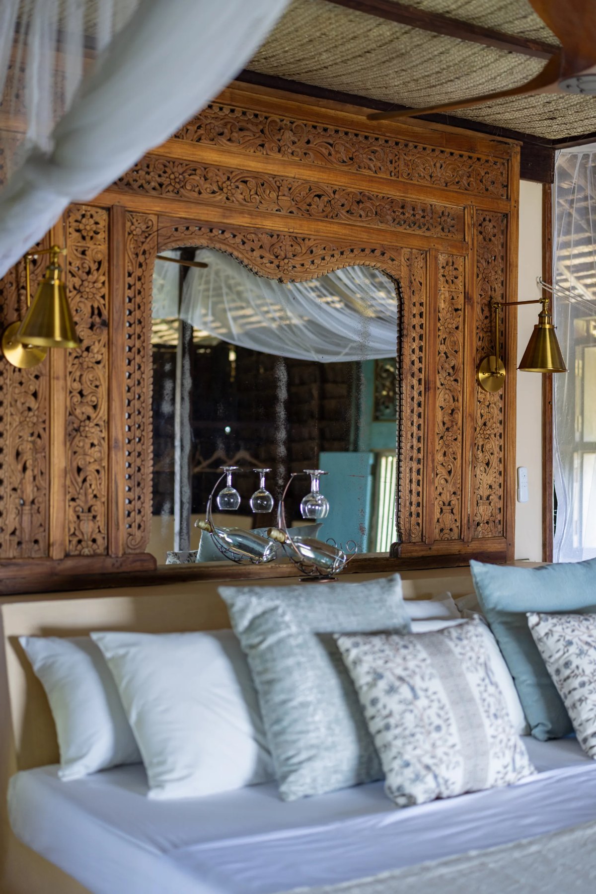 Moana cabana, carved Balinese headboard with brass reading lamps