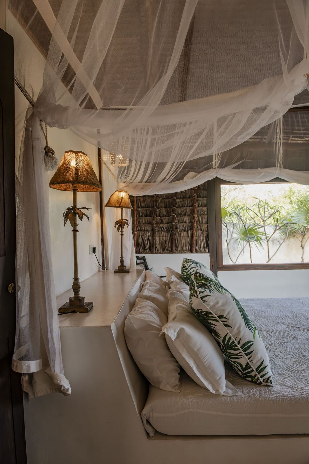 ʻOhana cabana — daybed lounge under makuti palm-thatch shade