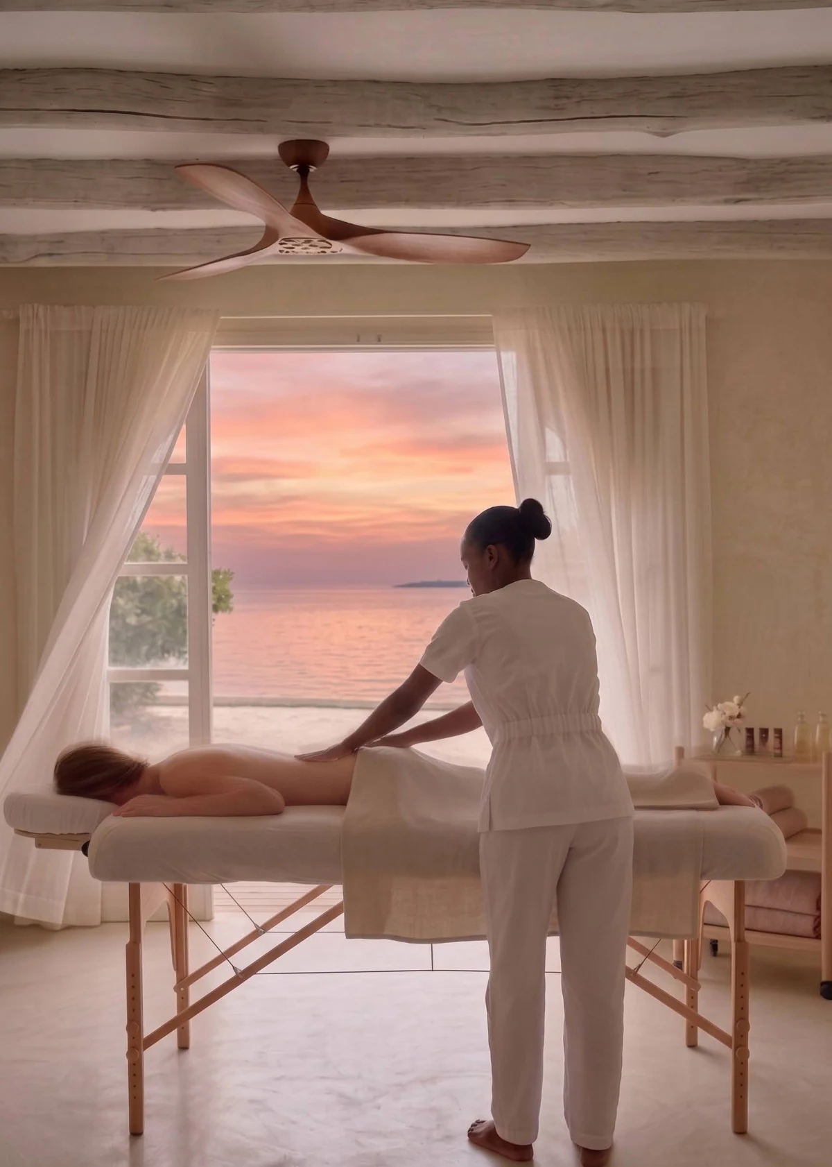 A massage in the Zen Den at sunset, sheer curtains and the sea beyond